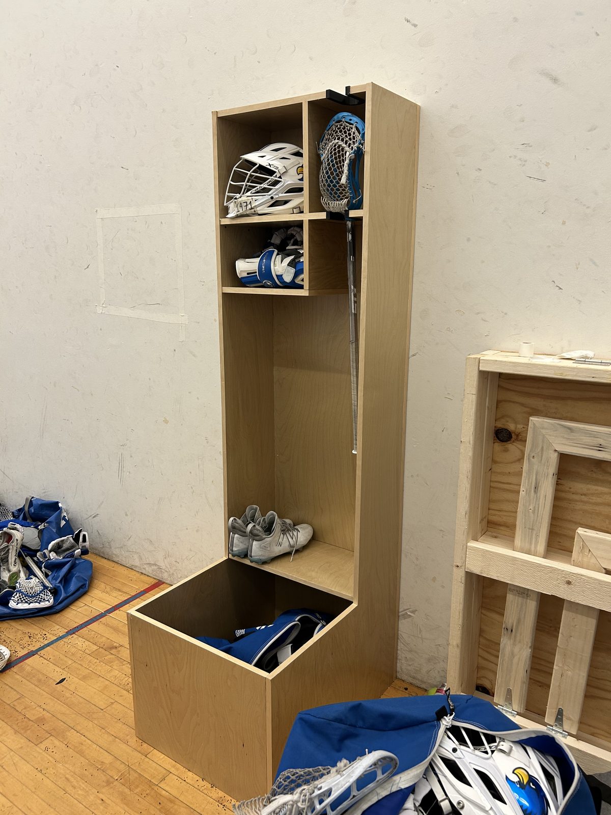 Prototype locker at Rockhurst University loaded with a helmet, stick, pads and cleats