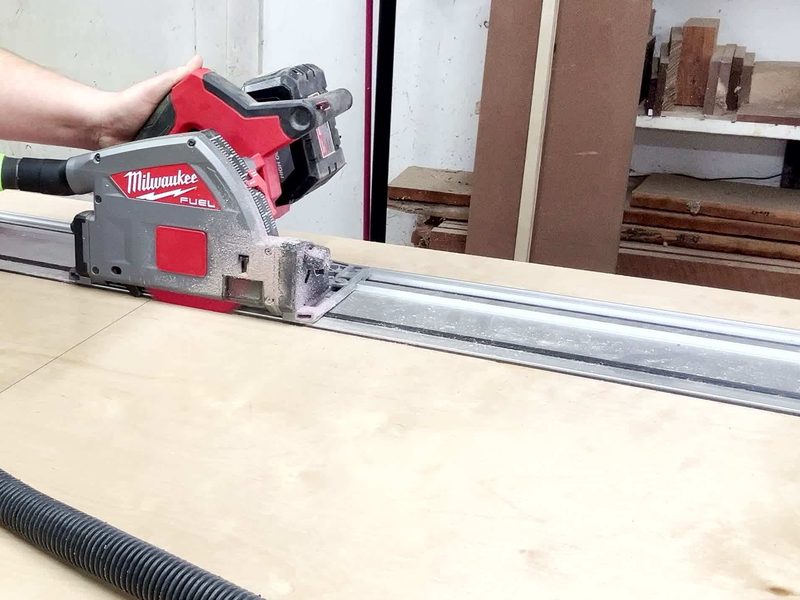 Track saw cutting a sheet of birch plywood along its guide rail