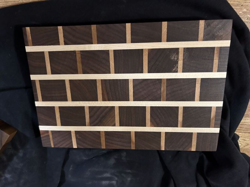End-grain walnut cutting board with maple strips in a brick pattern