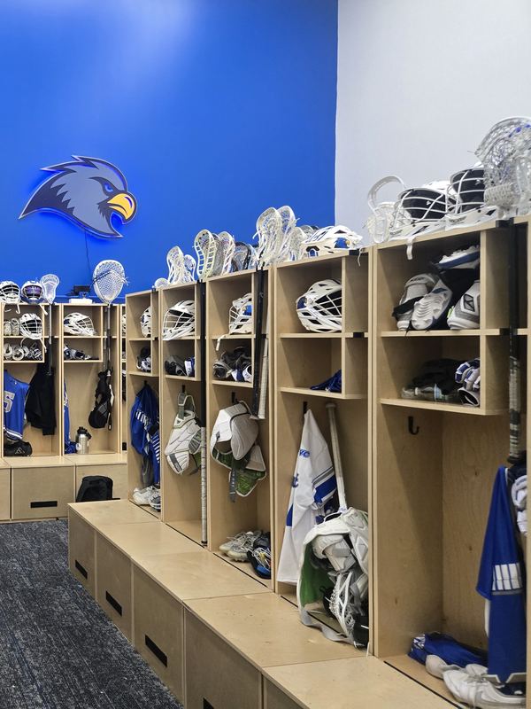 Row of birch lacrosse lockers with gear shelves and bench boxes